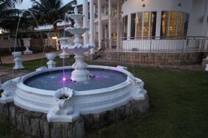 a fountain in a yard in front of a building at The Peacock Mansion in Kumasi