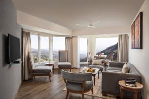 a living room with a couch and chairs and windows at Fortune Resort Grace, Mussoorie - Member ITC's Hotel Group in Mussoorie