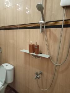 eine Dusche im Bad mit WC und Duschkopf in der Unterkunft Mahakali in Kelimutu