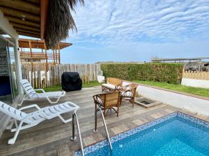 a patio with chairs and a swimming pool at Vichayito, Villa Chalaca in Vichayito