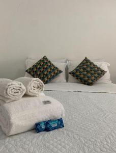 a white bed with towels and pillows on it at Chalé com Varanda Grande e Terraço Vista Mar in Itanhaém
