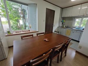 a kitchen with a long wooden table and chairs at Biei Snow House - Vacation STAY 14827 in Biei