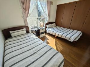 a bedroom with two beds and a window at Biei Snow House - Vacation STAY 14827 in Biei