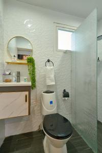 a bathroom with a toilet and a glass shower at La Suite 501 The Red Door in La Viva