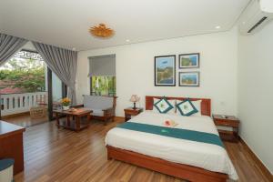 1 dormitorio con cama, escritorio y ventana en Betel Garden Villa, en Hoi An