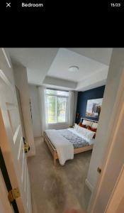 um quarto com uma cama e uma janela em Luxury Condo Near Calgary Airport em Calgary