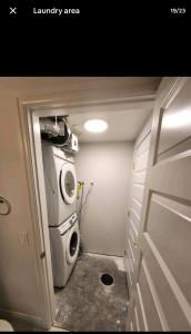 uma lavandaria com uma máquina de lavar roupa e uma máquina de lavar roupa em Luxury Condo Near Calgary Airport em Calgary