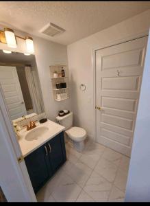 uma casa de banho com um lavatório, um WC e uma porta em Luxury Condo Near Calgary Airport em Calgary