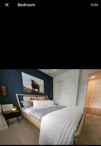 1 dormitorio con 1 cama con una pintura en la pared en Luxury Condo Near Calgary Airport, en Calgary