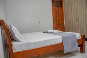 a small bed in a room with a white blanket on it at Destiny homes in Mombasa