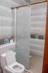 a bathroom with a toilet and a glass shower door at Destiny homes in Mombasa