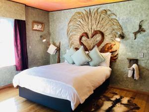 um quarto com uma cama grande e uma grande cabeceira. em Little Paradise Lodge em Creighton