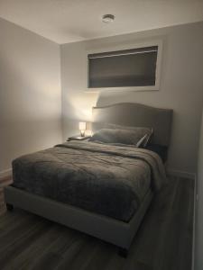 a bedroom with a bed with a lamp on it at Home Away From Home in Edmonton