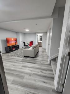 ein Wohnzimmer mit einem Sofa und einem TV in der Unterkunft Home Away From Home in Edmonton