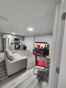 uma sala de estar com um sofá e cadeiras e uma televisão em Home Away From Home em Edmonton