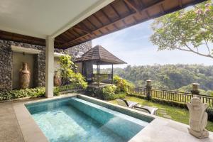 una piscina en el patio trasero de una casa con cenador en Rijasa Agung Resort and Villas, en Payangan