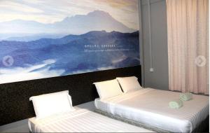 two beds in a room with a painting on the wall at Jabez Resort Kundasang in Kundasang