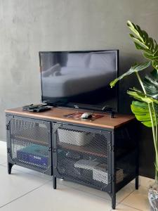 a tv on top of a stand with a television at Beacon Executive Suite - City View - By IZ in George Town