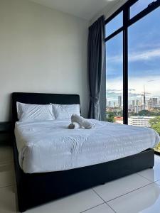Beacon Executive Suite - City View - By IZ في جورج تاون: حيوان محشوة أبيض ملقى على سرير مع نافذة