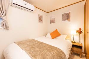 a small bedroom with a white bed and a window at アリタビル大国 in Osaka