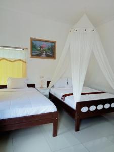 two beds with mosquito nets in a room at Mahakali in Kelimutu