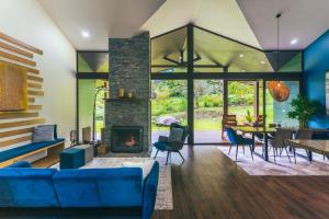 a living room with a blue couch and a fireplace at El Silencio Lodge & Spa Costa Rica in Toro Amarillo