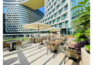 um pátio exterior com mesas e cadeiras e edifícios em First Class Apartments in Seven Palm with direct Access to the West Palm Beach and Nakheel Mall no Dubai