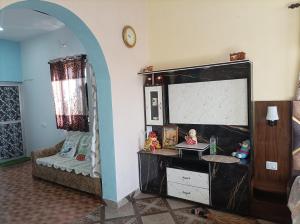 a living room with a dresser and a mirror at DHAULADHAR HOMESTAY PALAMPUR in Pālampur