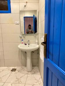 a man taking a picture of a bathroom with a sink at Blue House in Lighthouse in Dahab