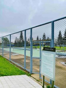 a chain link fence with a tennis court at SMDC Wind: T2 La Maison du Basa in Tagaytay +34 photos