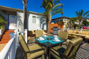 a patio with a table and chairs on a deck at Pacific Oasis - Large Patio, Parking & Walk to Beach in San Diego