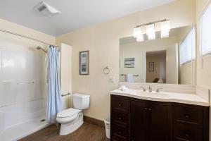 a bathroom with a toilet and a sink and a mirror at Pacific Oasis - Large Patio, Parking & Walk to Beach in San Diego
