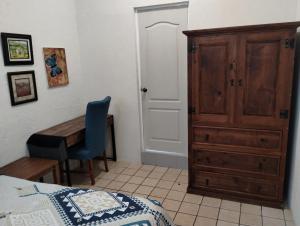 1 dormitorio con 1 cama, vestidor y escritorio en Tres Migueles, estudio Anna, cerca de la marina, zona turistica y playa, en Cabo San Lucas