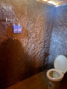 a bathroom with a toilet in a stone wall at D' Tepi Danau Glamping in Kintamani