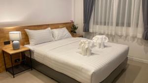 a bedroom with a bed with two white towels on it at B House Phuket @Chalong in Chalong 