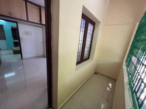 um quarto vazio com uma porta e uma janela em The best enclave em Chennai