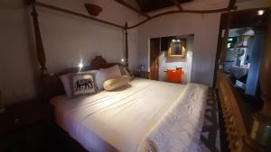 a bedroom with a large bed with white sheets and pillows at Vintekta Cottage in Weligama