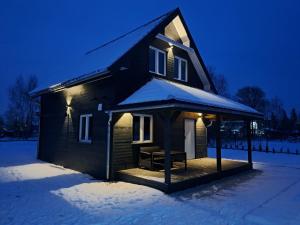 a small house with a gazebo in the snow at Karkonoskie Zacisze in Mysłakowice