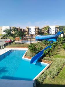 un parco acquatico con scivolo blu in un parco di Apartamento 3 Piscinas Tobogán y Zonas Verdes Cerca al Parque del Café a La Tebaida