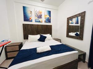 a bedroom with a large bed with blue sheets at Sky Elixia in Colombo
