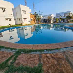 a large swimming pool in front of some buildings at Villa 65 - Eco Village - Easy Stays Yelagiri - Air Conditioned - Free Wifi - No Alcohol Zone in Yelagiri