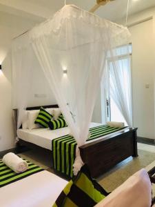 1 dormitorio con 2 camas y ventana en Nethu villa, en Galle