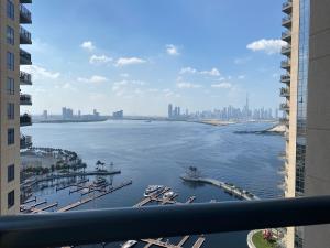 BJ's luxury Burj and Creek View 2 BR Apartment في دبي: منظر على جسم كبير من الماء من المبنى