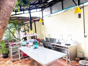 an outdoor kitchen with a table and a sink at Eco Inn in Phumĭ Réach Born (2)