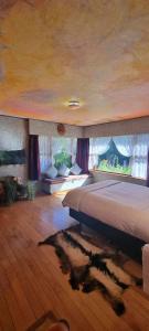 a bedroom with a large bed and a large window at Little Paradise Lodge in Creighton