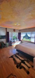 1 dormitorio con cama grande y ventana grande en Little Paradise Lodge, en Creighton