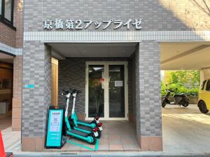 un edificio con due scooter parcheggiati fuori di マルチステイ大阪京橋 ad Osaka
