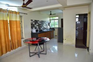 a kitchen with a glass table in a room at Field Stone -3 BHK duplex villa in Talaulim