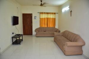 Sala de estar con 2 sofás y TV en Field Stone -3 BHK duplex villa en Talaulim