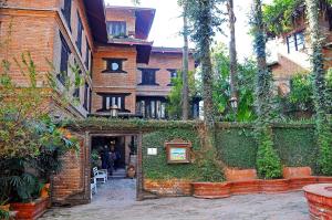 un bâtiment en briques avec du lierre sur son côté dans l'établissement Vajra Hotel, à Katmandou